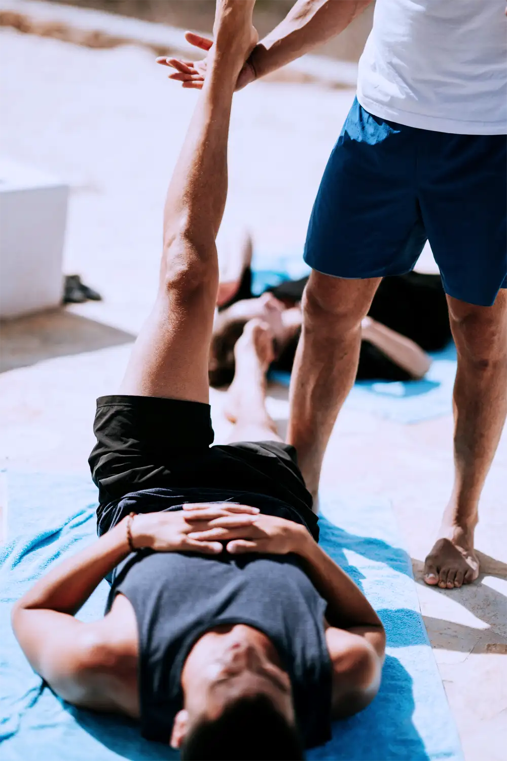 Hypermobility-Treatment-HSD Man lying down stretching with help from instructor.